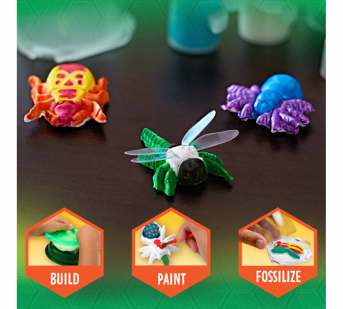 Critter Creator Metallic Bug Fossil Kit for Kids completed bug fossils on table.  Build. Paint. Fossilize.